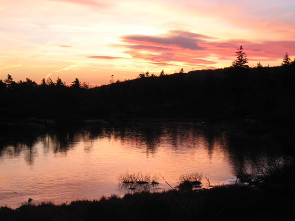 The sunset tints Featherbed Pond red.